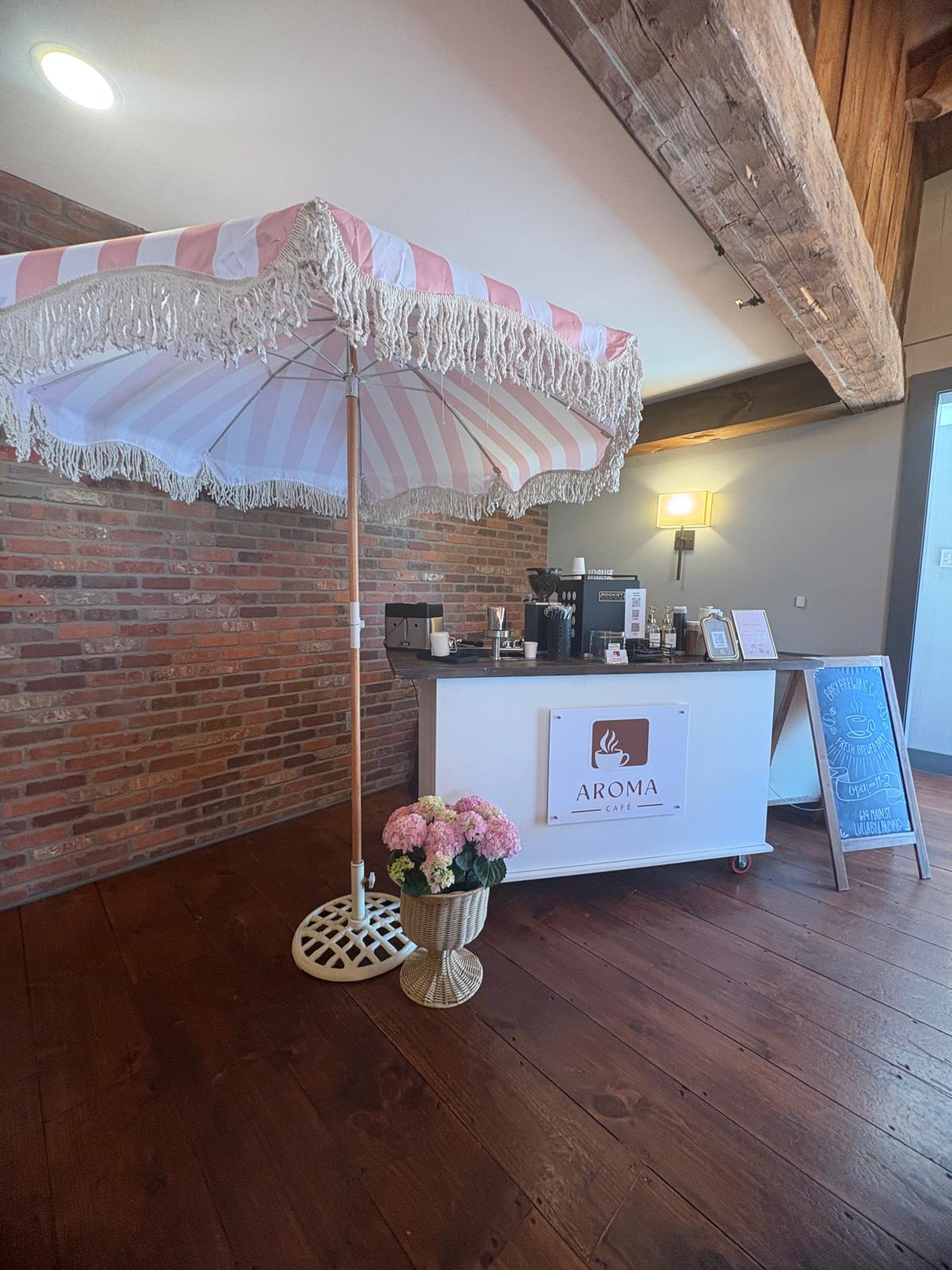 Pink-striped umbrella over the espresso cart