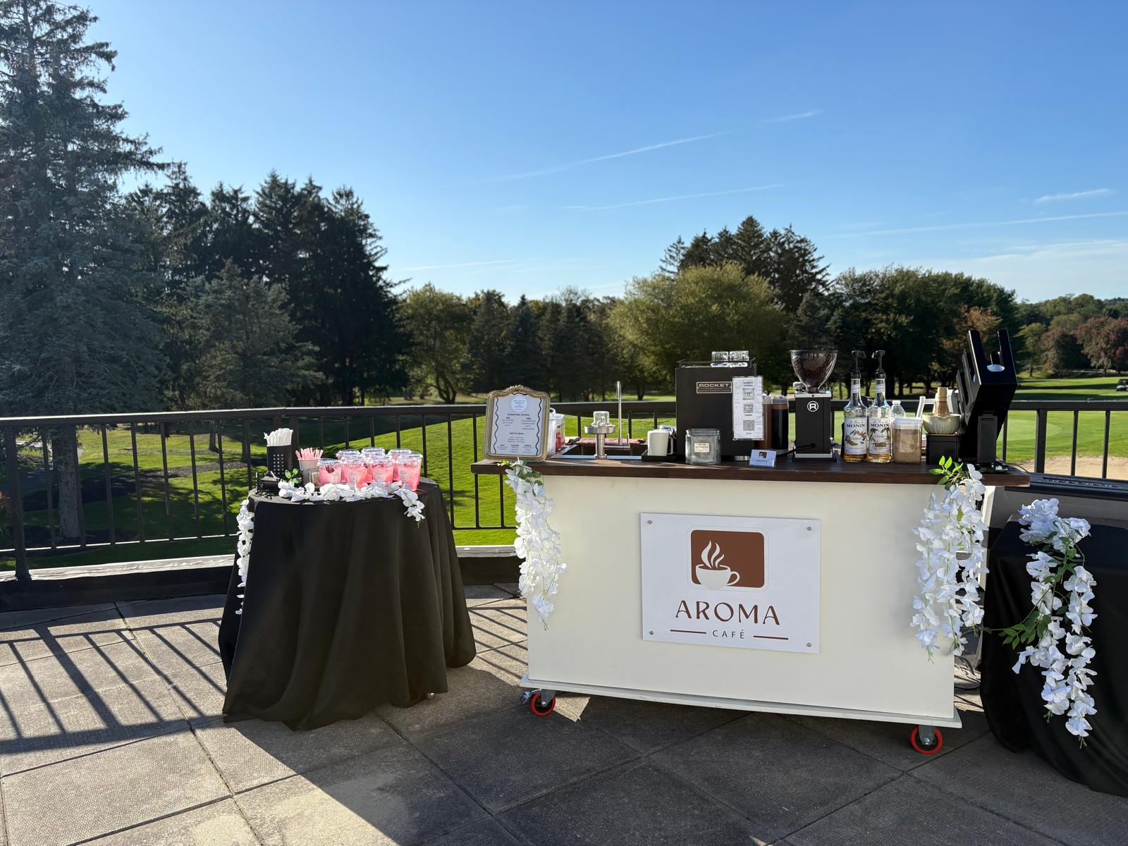 Aroma Café cart setup at an outdoor venue with green grounds and blue sky